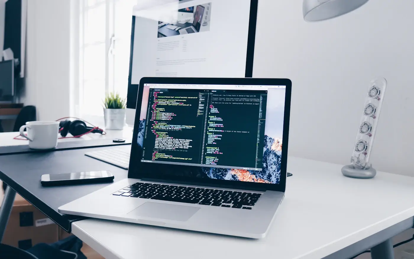 Laptop on a bright desk showing a website being built